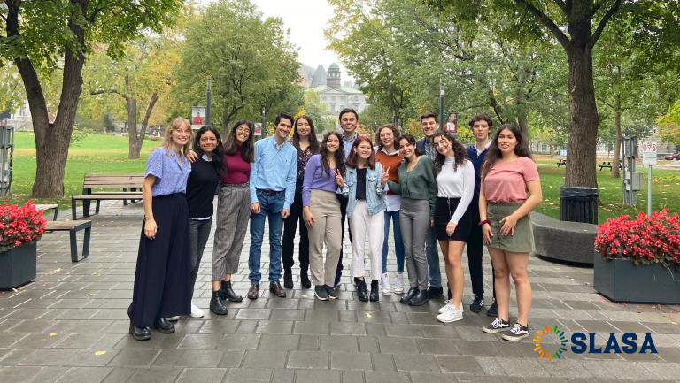 Image of various individuals posed in front of McGill on a summer day